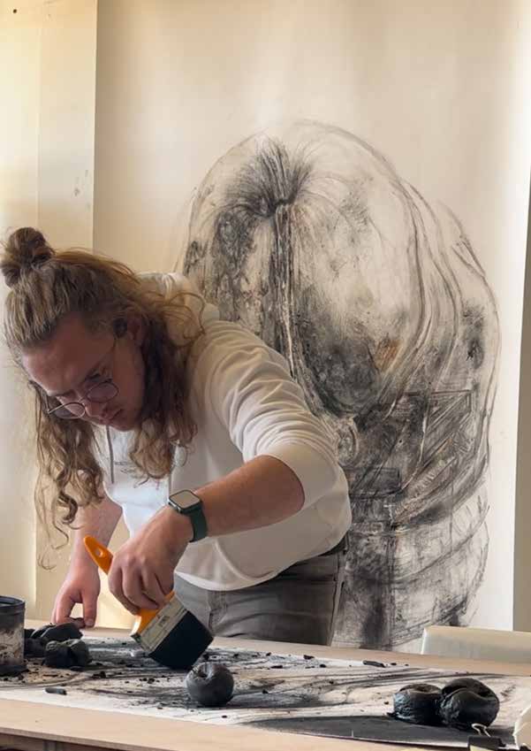 Brushing charcoal and burnt apples across a scroll drawing